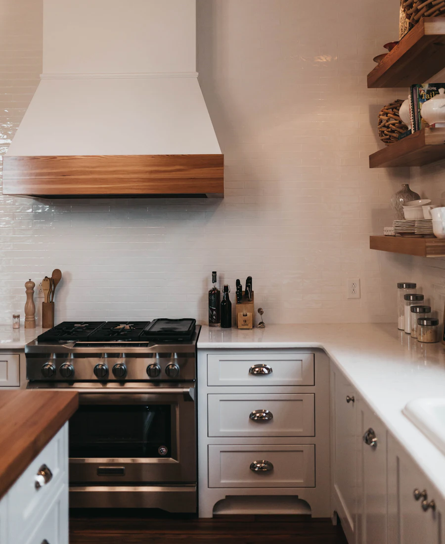 Warm kitchen with clean stone counters and a range hood